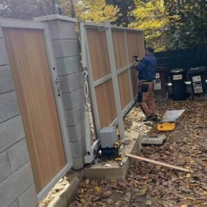 Completed long sliding gate finished with teak WPC fluted cladding in a vertical-slat design.