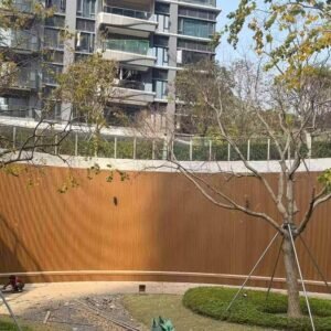 Curved courtyard facade finished with teak co-extrusion fluted cladding in a vertical ribbed pattern.