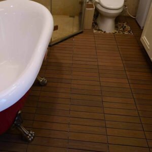 close up of teak wpc deck tile flooring cut around toilet base with drainage gap detail