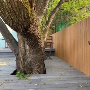 teak vertical composite fencing privacy wall next to decking and trees outdoor seating area